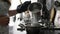 Woman pouring boiling water into pan at kitchen