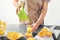 Woman pouring delicious citrus juice into glass on table