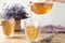 Woman pouring delicious lavender tea into glass at wooden table, closeup