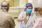 Woman pouring disinfectant gel on people entering the hospital.