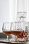 Woman pouring and drinking brandy of lead crystal bottle in cognac snifter glasses