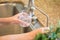 Woman Pouring Fresh Reverse Osmosis Purified Water Into Glass in