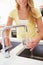 Woman Pouring Glass Of Water From Tap In Kitchen