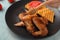 Woman pouring honey onto chicken wings, closeup