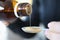 Woman pouring medicinal syrup into measuring spoon closeup