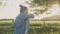 Woman pouring mineral water from bottle in glass, female drinking clear water with pleasure, sunset sun nature