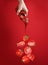 Woman pouring organic ketchup onto tomato against red background, closeup