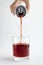 Woman pouring sweet flavoring soda drink into the glass, white background