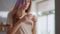 Woman pouring tea into cup on kitchen. Lady drinking tea at home