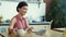 Woman pouring tea into cup during video call. Girl using laptop for video chat.