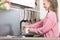 Woman pouring water in her kitchen