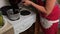 A woman pours blueberry puree into a saucepan. Making blueberry jam at home. Preservation and preparation of blueberries