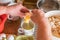 woman pours eggs separated yolk from egg white with a cup to make bread dumplings with bread crumbs, Germany