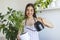 woman pours water into a flower pot, she cares for house plants. Young woman watering her plants