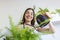 woman pours water into a flower pot, she cares for house plants. Young woman watering her plants