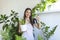 woman pours water into a flower pot, she cares for house plants. Young woman watering her plants