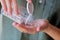 Woman pours white pills from a transparent jar into her hand