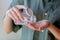 Woman pours white pills from a transparent jar into her hand