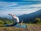 Woman practices yoga asana Anjaneyasana outdoors