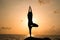 The woman practices yoga at dawn, there is an asana on a stone, dawn and an image of the girl, to enjoy dawn, to be happy with lif