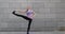 Woman practices yoga fitness exercise on pink mat in the city on grey urban background