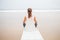 Woman practices yoga at the seashore on overcast day