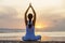 Woman practices yoga at the seashore at sunset on Bali in indonesia