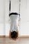 Woman practicing iyengar yoga using wall ropes in studio