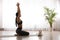 Woman practicing thunderbolt asana with cat in yoga studio. Vajrasana pose