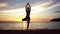 Woman practicing the tree yoga pose on a beach at sunset during summer vacation