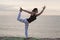 Woman practicing yoga on the beach. King Dancer Pose, Natarajasana. Outdoors sports. Healthy living.