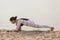 Woman practicing yoga on the beach. Utthan Pristhasana, Lizard pose. Outdoors sports. Healthy living