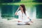 Woman practicing yoga breathing technique by the lake