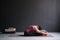 Woman practicing yoga, doing Seated forward bend pose, using bolster.