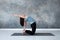 Woman practicing yoga, doing Ushtrasana, Camel Pose, at studio full length.