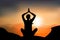 Woman practicing yoga lotus pose on mountain with sunset, calm environnement for breathing, concentrate and recovering energy