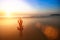 Woman practicing yoga on sea beach during wonderful sunset.