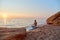 Woman practicing yoga on seashore. Meditation on beach at sunset. Relax in nature. Contemplation and meditation idea