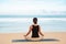 woman practicing yoga at seashore of tropic beach,young woman meditating at the beach make yoga exercises