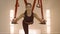 Woman practicing yoga with straps in studio. Serious lady training indoors