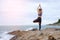 The woman practicing yoga sunset on the beach.