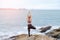 The woman practicing yoga sunset on the beach.