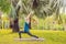 Woman practicing yoga in a tropical park