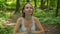 Woman practises yoga in forest. Young girl meditates nature outdoors, slow motion. Concept of fitness, healthy lifestyle