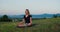 Woman practises yoga at sunrise under the tree. Young spiritual girl meditates in lotus pose nature outdoors, slow motion