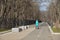 Woman with pram walking along alley in early spring in Dubki Park in Northern Administrative District. Moscow, Russia