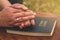 Woman praying on bible background. Hands folded in prayer concept for faith, spirituality and religion.