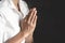 Woman Praying hands with faith in religion and belief in God On the dark background. Namaste or Namaskar hands gesture, Pay