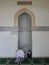 Woman praying inside Lulua Mosque in Cairo, Egypt - Ancient architecture - Holy Islamic site - Africa religious tour