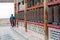 Woman Is Praying By Rotating Cylinders In Buddhist Temple